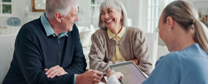 Happy, old couple and caregiver in home